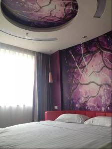 um quarto com uma cama e uma parede roxa em Thank Inn Chain Hotel Hubei Wuhan Dongxihu District Jinghe Street em Wuhan