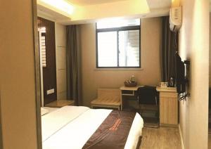 sypialnia z łóżkiem, biurkiem i oknem w obiekcie JUNYI Hotel Jiangsu Xuzhou Middle Xiyuan Road w mieście Xuzhou