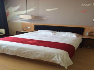 een slaapkamer met een groot bed en een rode deken bij JUNYI Hotel Jiangsu Nanjing University of Information Science and Technology in Nanjing