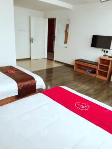 um quarto de hotel com duas camas e uma televisão de ecrã plano em Thank Inn Plus Hotel Jiangsu Taizhou Taixing Jingjiang Primary School em Taixing