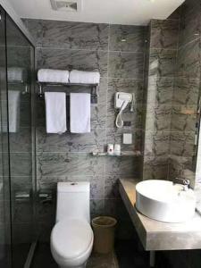 La salle de bains est pourvue de toilettes et d'un lavabo. dans l'établissement Thank Inn Chain Hotel Zhejiang Hangzhou West Lake District, Sandun County, Oulubao Plaza, à Libu