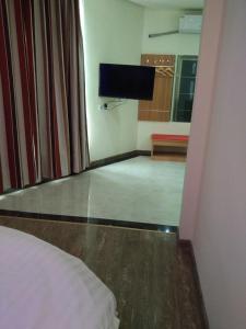 a room with a bed and a flat screen tv at Thank Inn Chain Shangdong Zaozhuang Tengjingzhou Jinghe Bridge Haishang Mingyue in Tengzhou