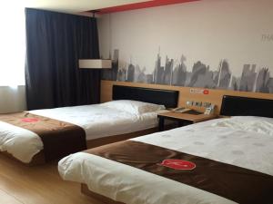 een hotelkamer met 2 bedden en een muur bij JUNYI Hotel Jiangsu Nanjing University of Information Science and Technology in Nanjing
