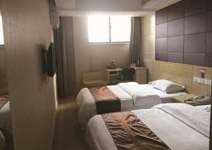 Pokój hotelowy z 2 łóżkami i biurkiem w obiekcie JUNYI Hotel Jiangsu Xuzhou Middle Xiyuan Road w mieście Xuzhou