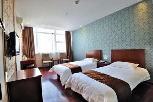 a hotel room with two beds and a television at JUNYI Hotel Jiangsu Suzhou Industrial Park Chefang Songze in Suzhou