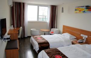 a hotel room with two beds and a desk at Thank Inn Chain Hotel Jiangsu Huaian Lianshui Dongding in Paifang