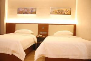 a hospital room with two beds with white sheets at Thank Inn Plus Hotel Fengxian Xidu in Xidu