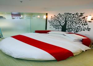 una camera da letto con un grande letto con una coperta rossa e bianca di Thank Inn Chain Hotel Hebei Handan Guantao Zhuxian Road a Nanxinzhuang