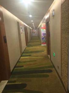 a long hallway with colorful floors in a building at Thank Inn Chain Hotel Zhejiang Huzhou Changxing Town Qingfang City in Jiapu