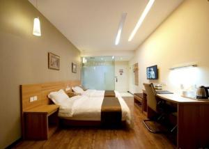 1 dormitorio con 1 cama y escritorio con ordenador en Thank Inn Chain Hotel Jiangsu Yangzhou Shaobo Grand Canal, en Yangzhou