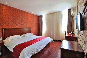 a hotel room with a bed and a flat screen tv at JUNYI Hotel Jiangsu Suzhou Industrial Park Chefang Songze in Suzhou
