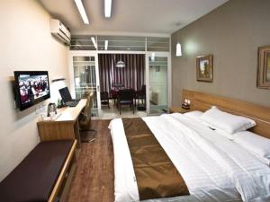 a hotel room with a large bed and a desk at Thank Inn Chain Hotel Jiangsu Yangzhou Shaobo Grand Canal in Yangzhou