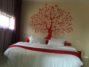 a bedroom with a tree mural on the wall at Thank Inn Chain Hotel Jiangsu Suzhou Wujiang Pedestrian Street in Suzhou