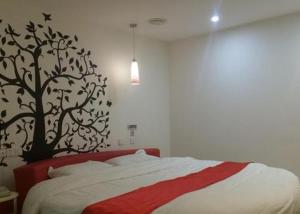 a bedroom with a bed with a tree on the wall at Thank Inn Chain Hotel Jiangsu Jiangyan Pedestrian Street in Taizhou