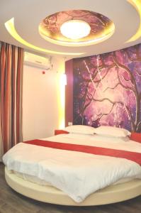 a bedroom with a large bed with a colorful wall at Thank Inn Chain Hotel Shandong Qingdao Junfeng Road in Qingdao