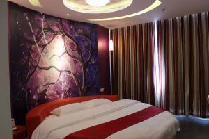 ShiliushuにあるThank Inn Chain Hotel Jiangsu Lianyungang Donghai North Niushan Roadのベッドルーム1室(壁に絵画が描かれた大型ベッド1台付)