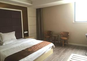 pokój hotelowy z łóżkiem i 2 krzesłami w obiekcie JUNYI Hotel Jiangsu Xuzhou Middle Xiyuan Road w mieście Xuzhou