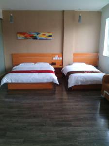 duas camas num quarto de hotel com duas saias em Thank Inn Chain Hotel Shanxi Lvliang Jiaokou County West Street em Xiazhuang