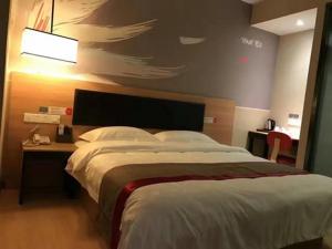 - une chambre avec un grand lit et un bureau avec une lampe dans l'établissement Thank Inn Chain Hotel Zhejiang Hangzhou West Lake District, Sandun County, Oulubao Plaza, à Libu