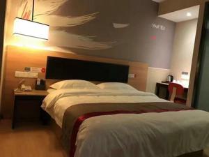 - une chambre avec un grand lit et une table avec une lampe dans l'établissement Thank Inn Chain Hotel Zhejiang Hangzhou West Lake District, Sandun County, Oulubao Plaza, à Libu