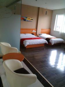 um quarto com 2 camas, uma mesa e cadeiras em Thank Inn Chain Hotel Shanxi Lvliang Jiaokou County West Street em Xiazhuang