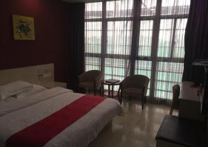 1 dormitorio con cama, mesa y ventanas en Thank Inn Chain Hotel Jiangsu Suzhou Wujiang Pedestrian Street, en Suzhou