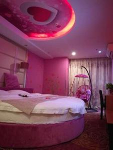 a bedroom with a large bed with a pink ceiling at Thank Inn Chain Hotel Zhejiang Huzhou Changxing Town Qingfang City in Jiapu