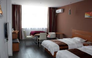 ShiliushuにあるThank Inn Chain Hotel Jiangsu Lianyungang Donghai North Niushan Roadのベッド2台、テーブルと椅子が備わるホテルルームです。