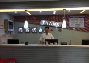 a man standing behind a counter in a restaurant at Thank Inn Chain Hotel Jiangsu Jiangyan Pedestrian Street in Taizhou