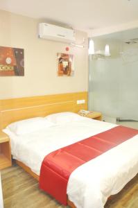 um quarto com uma grande cama branca e um cobertor vermelho em Thank Inn Chain Hotel Shandong Qingdao Junfeng Road em Qingdao