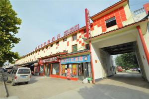 um edifício com uma carrinha estacionada em frente em Thank Inn Chain Hotel Lanshan District Baishahu Town em Linyi