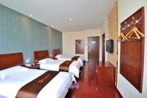 a hotel room with three beds and a television at JUNYI Hotel Jiangsu Suzhou Industrial Park Chefang Songze in Suzhou