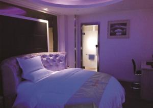 Fioletowa sypialnia z dużym łóżkiem i drzwiami w obiekcie JUNYI Hotel Jiangsu Xuzhou Middle Xiyuan Road w mieście Xuzhou