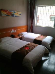 um quarto de hotel com duas camas e uma janela em Thank Inn Chain Hotel Shanxi Lvliang Jiaokou County West Street em Xiazhuang