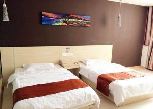 1 dormitorio con 2 camas y TV en la pared en Thank Inn Chain Hotel Jiangsu Jiangyan Pedestrian Street en Taizhou