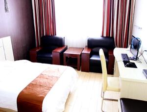 Cette chambre comprend un lit et un bureau avec un ordinateur. dans l'établissement Thank Inn Chain Hotel Shanxi Jinzhong Shouyang Chaoyang Road, à Shouyang