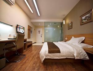 1 dormitorio con cama, escritorio y ordenador en Thank Inn Chain Hotel Jiangsu Yangzhou Shaobo Grand Canal, en Yangzhou