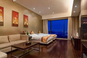 um quarto de hotel com uma cama e um sofá em HeeFun Apartment GZ -Poly World Trading Center-walking distance to Canton Fair em Guangzhou