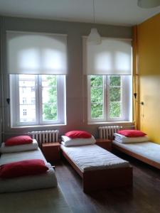 three beds in a room with three windows at Szkolne Schronisko Młodzieżowe w Gdańsku in Gdańsk