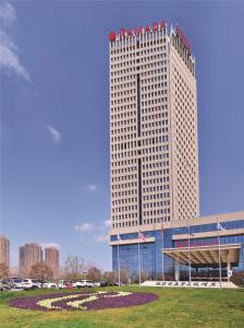 a tall building with flags on top of it at Ramada Heze in Heze