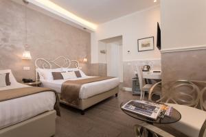 a hotel room with two beds and a table at Relais de l'Opera - Relais de l'Opera Group in Rome