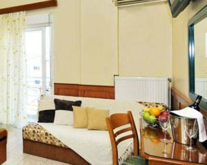 a bedroom with a bed, a dresser and a window at Hotel Admitos in Volos