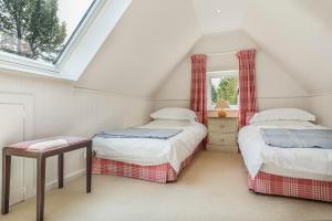a attic bedroom with two beds and a window at The Duck House in Cowden