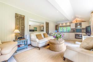 a living room with white furniture and a kitchen at The Duck House in Cowden