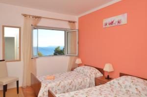 ein Schlafzimmer mit zwei Betten und einem Fenster in der Unterkunft Apartments Daniela in Zavalatica