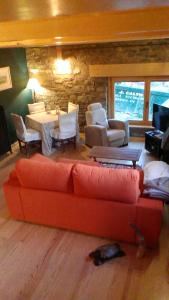ein Wohnzimmer mit einem roten Sofa und einem Tisch in der Unterkunft Casa Rural Pirineo Aragonés in Biescas