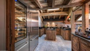 a kitchen with wooden cabinets and stainless steel appliances at La Ferme de Juliette in Le Grand-Bornand