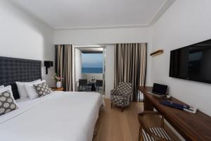 a hotel room with a bed and a flat screen tv at Aquila Atlantis Hotel in Heraklio Town
