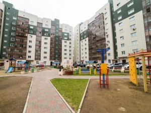 einen Spielplatz in einer Stadt mit hohen Gebäuden in der Unterkunft Апартаменты на 78-й Добровольческой Бригады - 28 in Krasnojarsk
