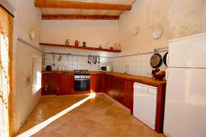 a kitchen with red cabinets and a white refrigerator at Quality Villa Es Molí in Porreres